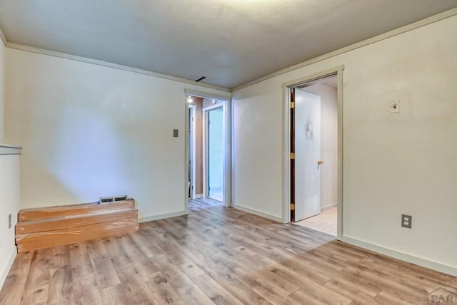 unfurnished room with baseboards and light wood-style floors