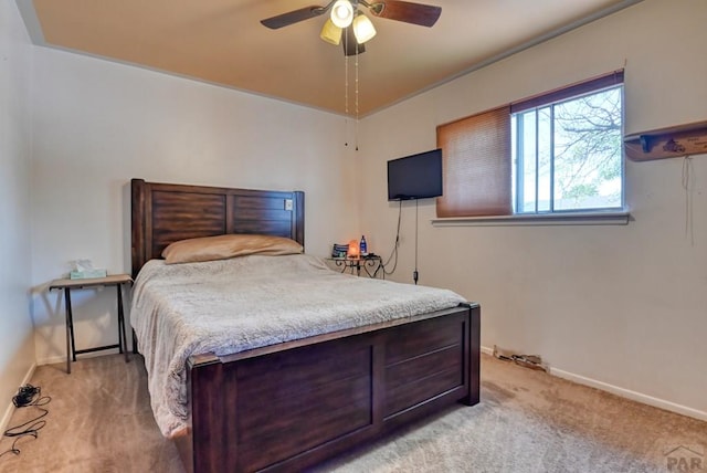 bedroom with a ceiling fan, light carpet, and baseboards