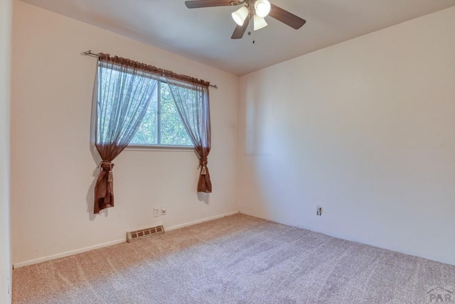 carpeted empty room featuring visible vents and a ceiling fan