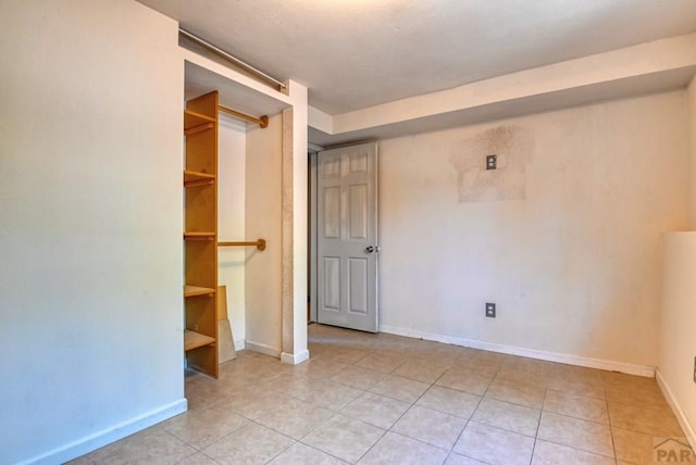 unfurnished bedroom with light tile patterned floors and baseboards