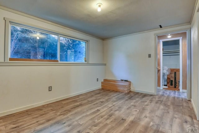 empty room featuring light wood-type flooring and baseboards