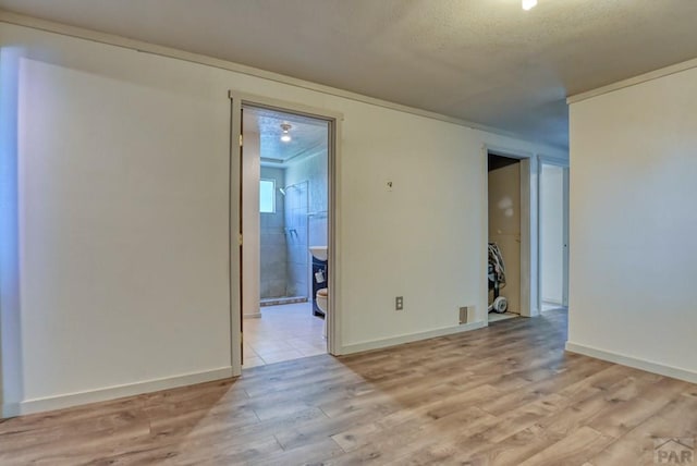 unfurnished room with light wood-style flooring and baseboards