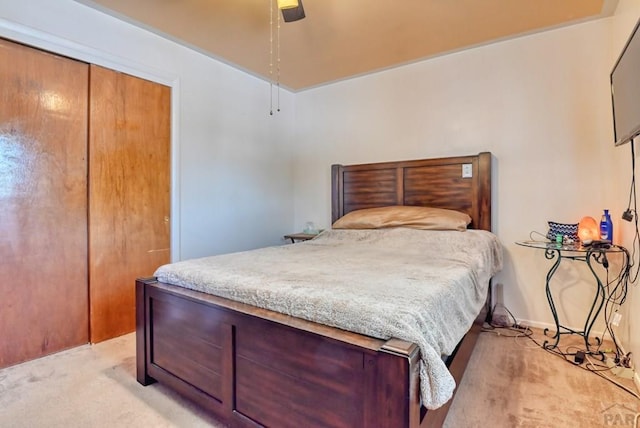 bedroom featuring light carpet, a closet, and a ceiling fan