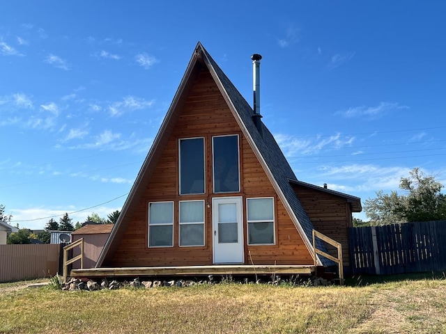 rear view of property featuring fence