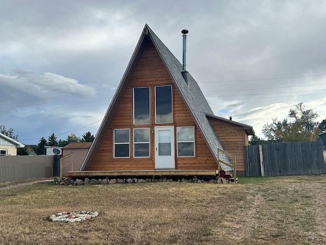 view of side of property with fence, a lawn, and an outbuilding