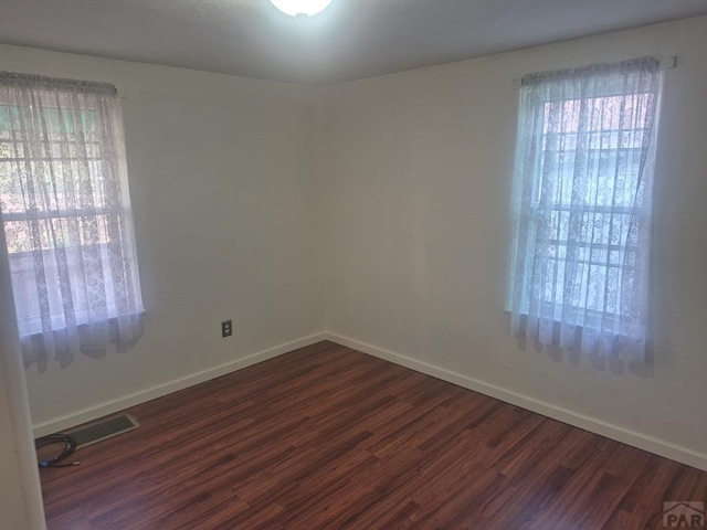 1122 Raton Ave, La Junta, CO 81050 - spare room with healthy amount of natural light and dark wood finished floors