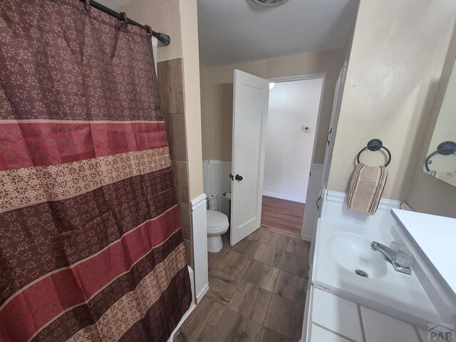 1122 Raton Ave, La Junta, CO 81050 - bathroom with vanity, wainscoting, and a shower with shower curtain