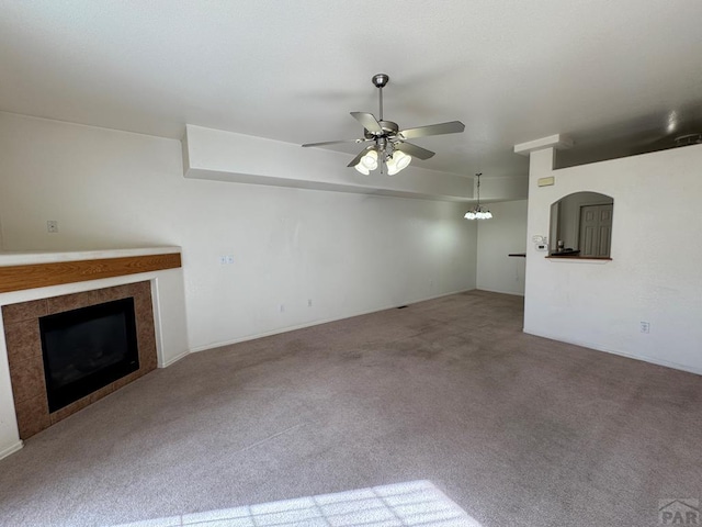 4147 Outlook Blvd Unit F, Pueblo, CO 81008 - unfurnished living room featuring ceiling fan, carpet flooring, and a tile fireplace