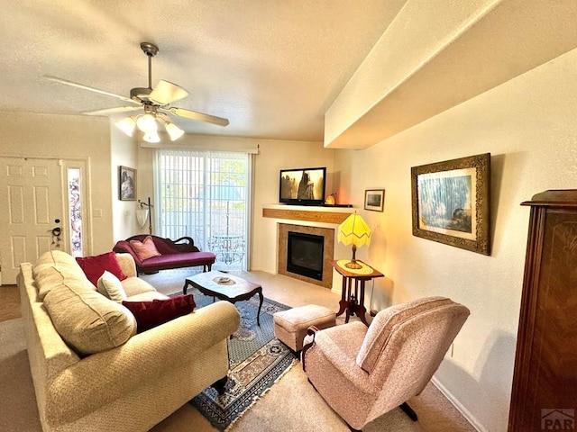 4147 Outlook Blvd Unit F, Pueblo, CO 81008 - living area with ceiling fan, a textured ceiling, carpet floors, a tiled fireplace, and baseboards