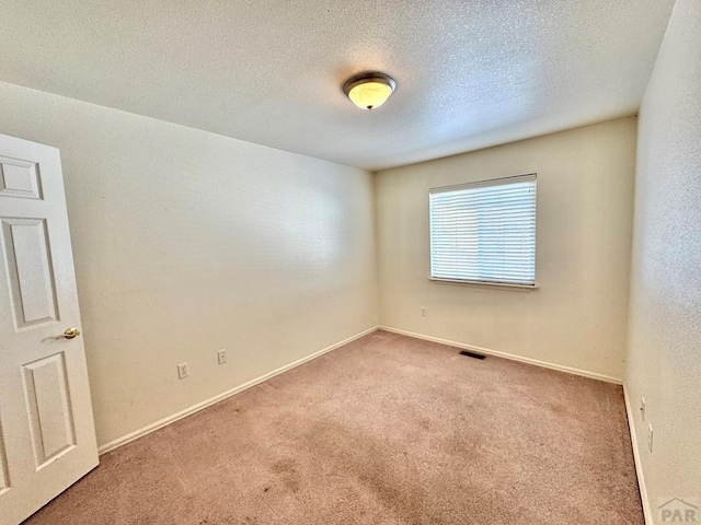 4147 Outlook Blvd Unit F, Pueblo, CO 81008 - carpeted spare room with visible vents, a textured ceiling, and baseboards