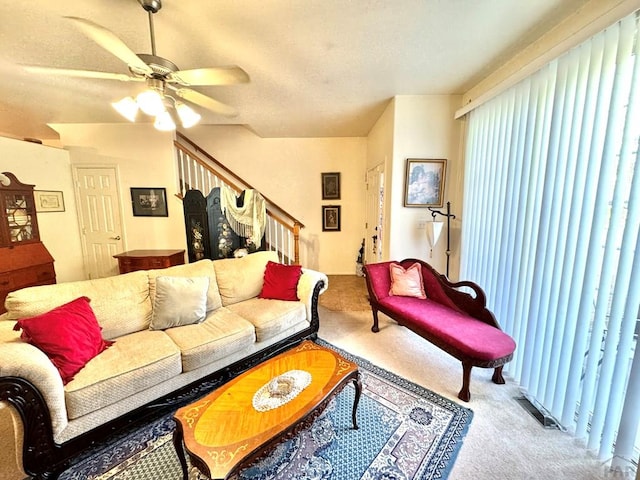 4147 Outlook Blvd Unit F, Pueblo, CO 81008 - carpeted living room with a textured ceiling, ceiling fan, visible vents, and stairs