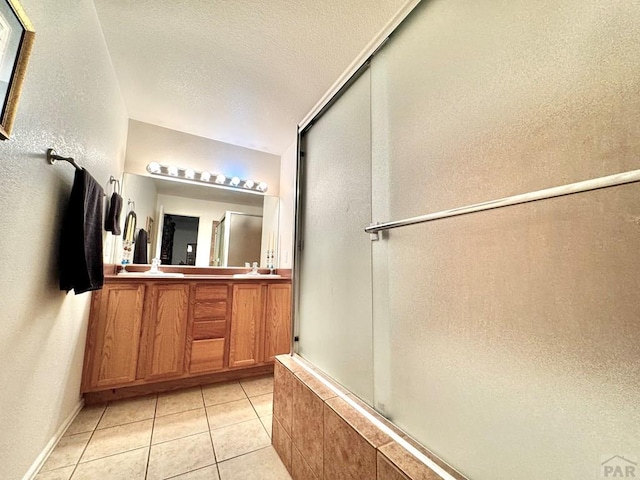 4147 Outlook Blvd Unit F, Pueblo, CO 81008 - full bathroom featuring a shower with door, double vanity, a textured wall, tile patterned floors, and a textured ceiling