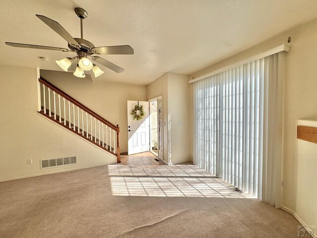 4147 Outlook Blvd Unit F, Pueblo, CO 81008 - foyer with a textured ceiling, a ceiling fan, stairs, visible vents, and carpet