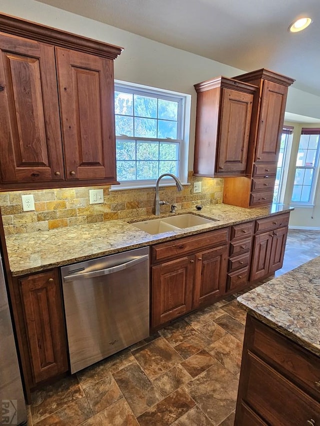 kitchen featuring light stone counters, backsplash, stainless steel dishwasher, a sink, and recessed lighting