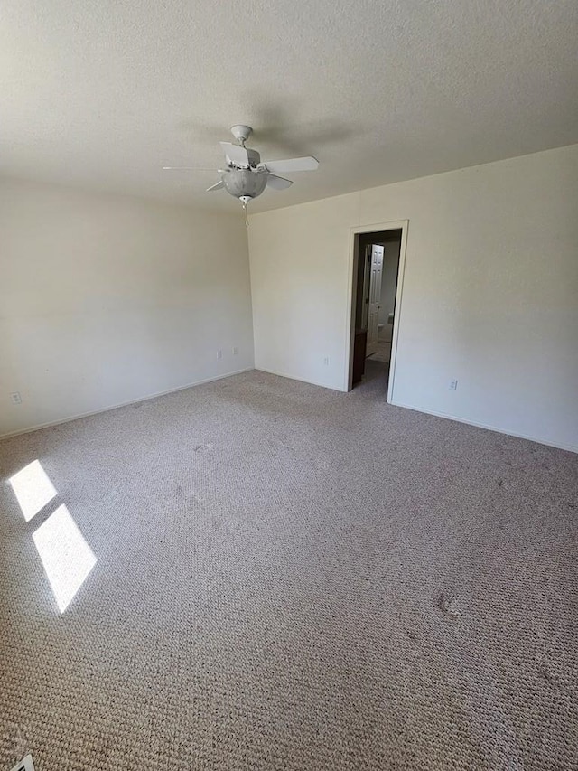 carpeted spare room featuring ceiling fan and a textured ceiling