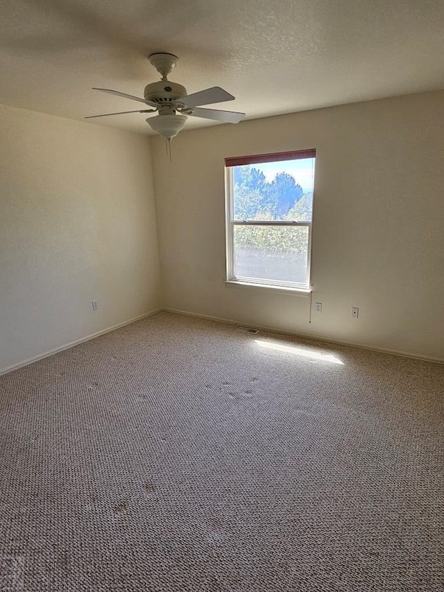 spare room featuring carpet floors, ceiling fan, a textured ceiling, and baseboards