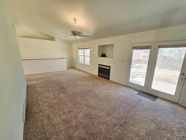 unfurnished living room featuring carpet, a fireplace, visible vents, a ceiling fan, and vaulted ceiling