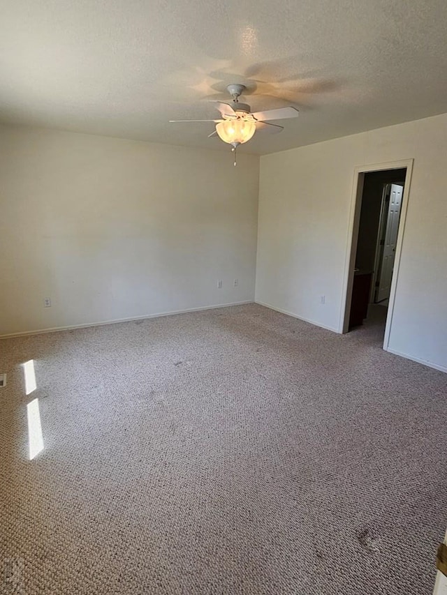 spare room featuring carpet, ceiling fan, a textured ceiling, and baseboards