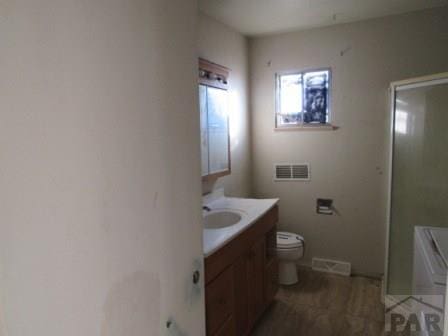 full bath with toilet, vanity, and visible vents