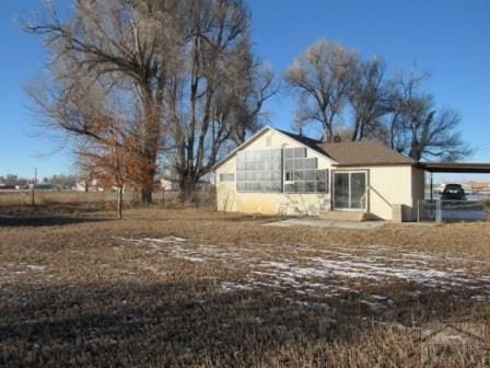 back of house featuring a carport