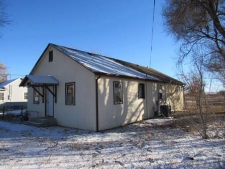 view of snowy exterior featuring stucco siding