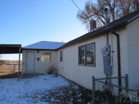 exterior space with entry steps, fence, a chimney, and stucco siding