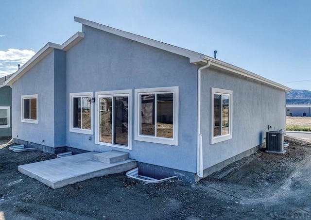 back of property with stucco siding, a patio, and central AC unit