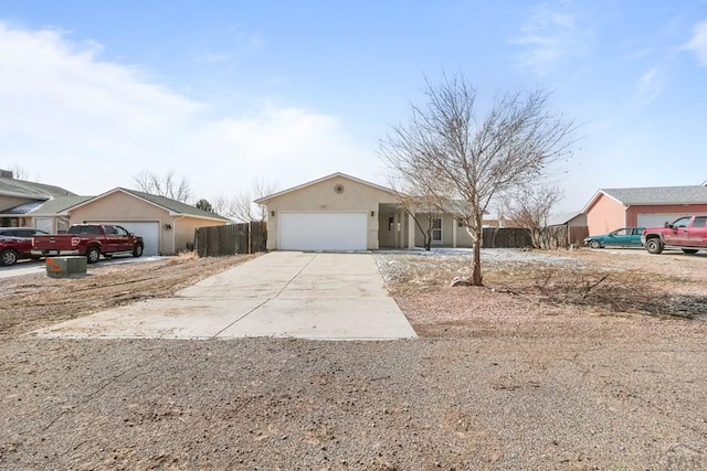 single story home with concrete driveway, an attached garage, and fence