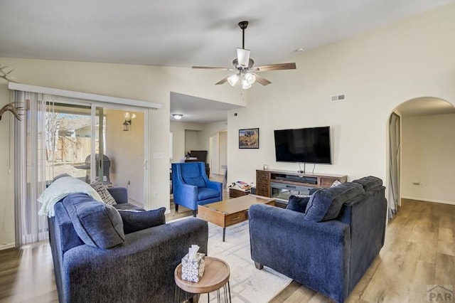 5019 Sage St, Pueblo, CO 81005 - living room with arched walkways, light wood finished floors, a ceiling fan, baseboards, and high vaulted ceiling