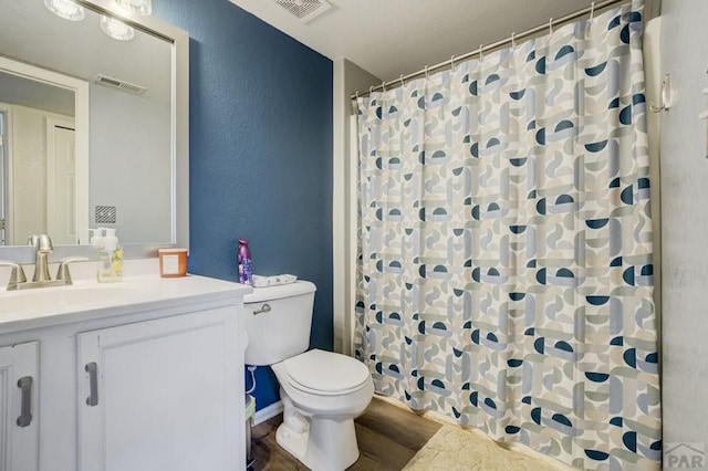 5019 Sage St, Pueblo, CO 81005 - bathroom with toilet, vanity, a textured wall, wood finished floors, and a shower with shower curtain