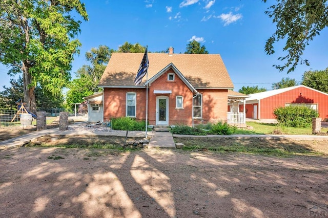 bungalow-style house with a shingled roof, brick siding, and fence