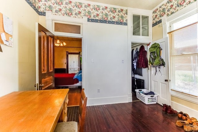 interior space with crown molding, baseboards, and wood finished floors
