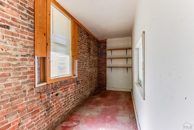 interior space with concrete flooring and brick wall