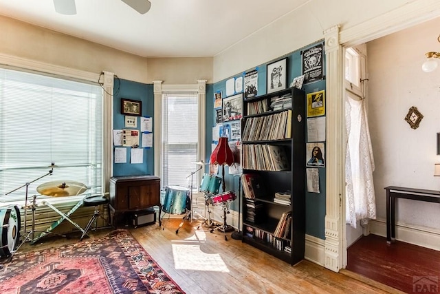 interior space with baseboards, a ceiling fan, and wood finished floors