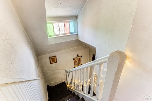 stairway featuring a textured wall