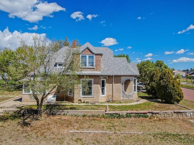 view of front of house with a chimney and stucco siding