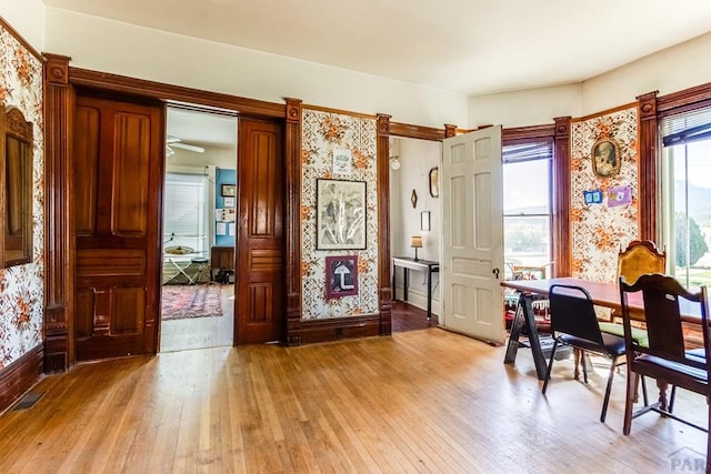 office space with baseboards, ceiling fan, light wood-style flooring, and visible vents