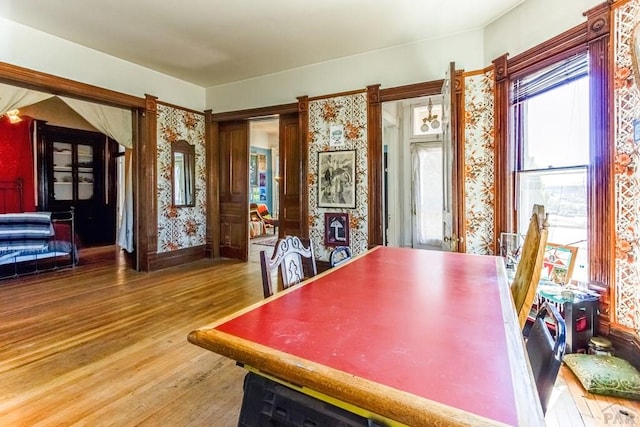 dining room with wallpapered walls and wood finished floors