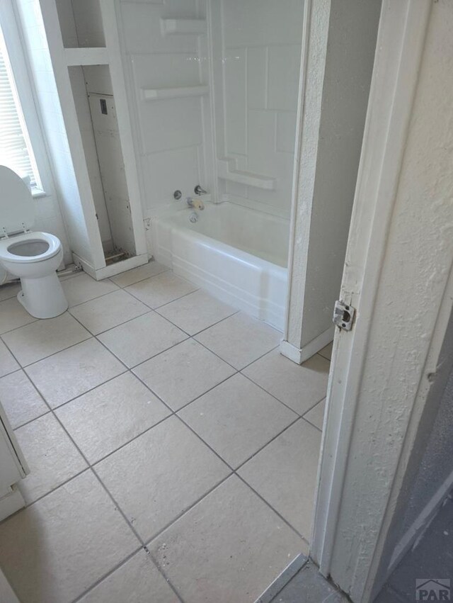 full bath with bathtub / shower combination, toilet, and tile patterned floors