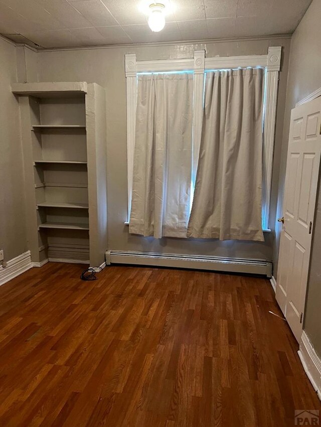 interior space with dark wood-style floors, a baseboard radiator, and baseboards