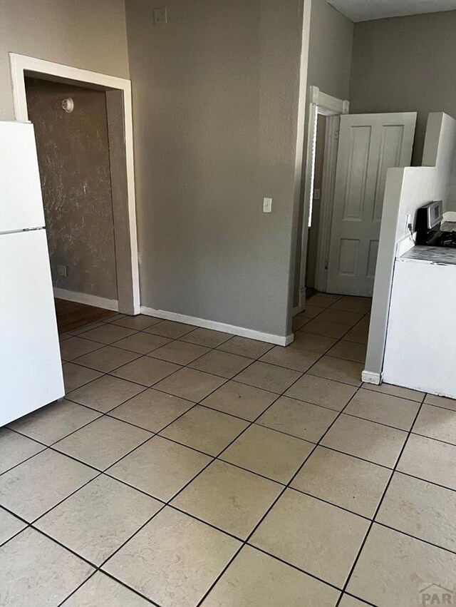 interior space featuring light tile patterned floors and baseboards