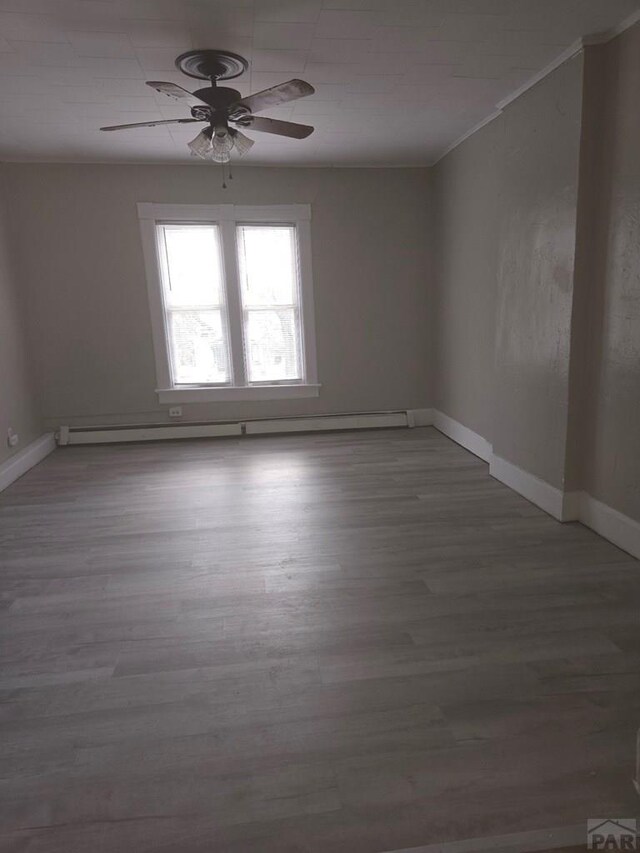 spare room featuring a ceiling fan, baseboards, and wood finished floors