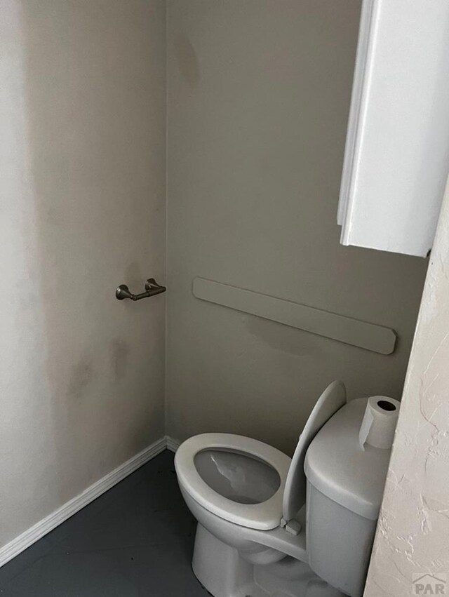 bathroom featuring baseboards and toilet