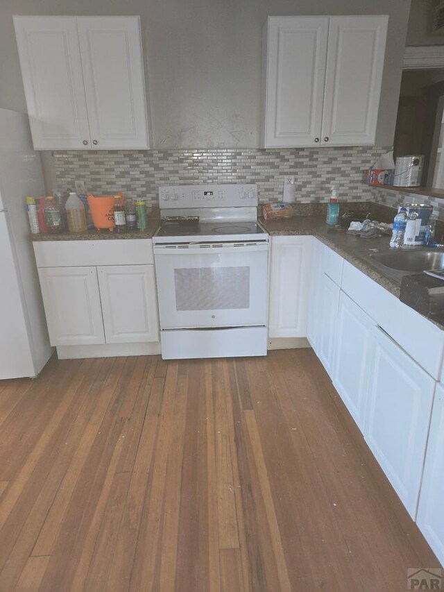 kitchen featuring dark wood-style floors, backsplash, electric range, freestanding refrigerator, and white cabinets