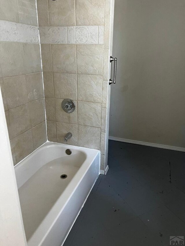 bathroom featuring washtub / shower combination and baseboards