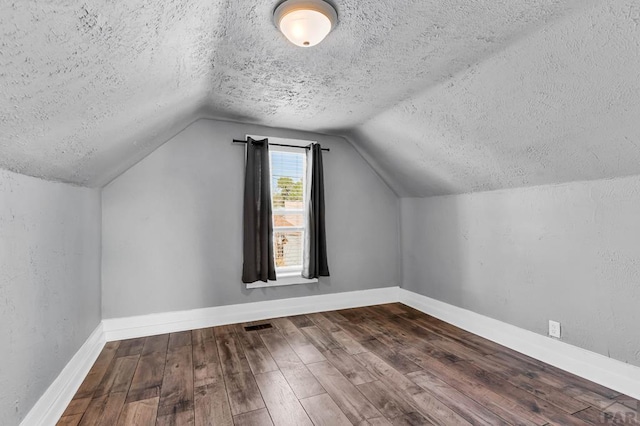 1131 Pine St, Pueblo, CO 81004 - bonus room with a textured ceiling, baseboards, visible vents, lofted ceiling, and wood-type flooring