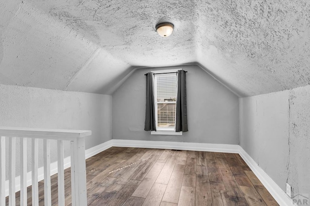 1131 Pine St, Pueblo, CO 81004 - additional living space featuring hardwood / wood-style floors, baseboards, a textured ceiling, and lofted ceiling