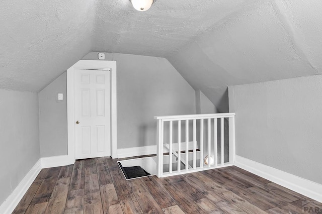 1131 Pine St, Pueblo, CO 81004 - additional living space with vaulted ceiling, wood finished floors, and a textured ceiling
