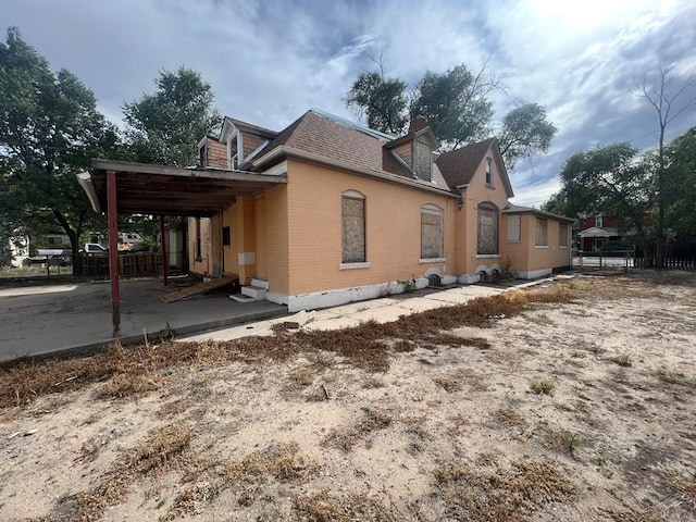 view of property exterior featuring brick siding and roof with shingles