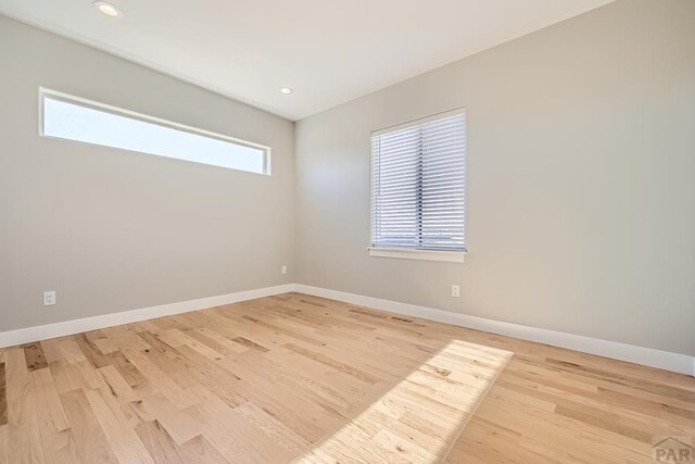 empty room with light wood finished floors, baseboards, and recessed lighting